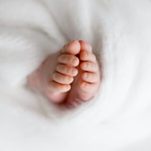 Pasgeboren baby in zachte doeken tijdens newborn fotoshoot Zeeland